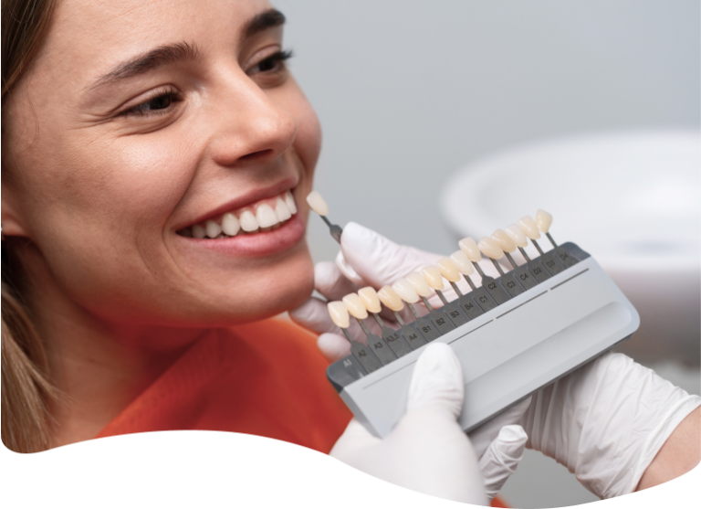 woman with a toothbrush in her mouth holding a model of teeth