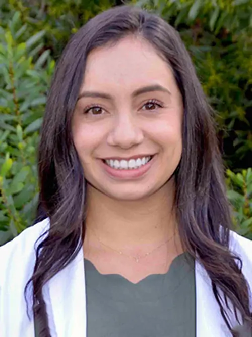 a close up of a woman with long hair and a white jacket