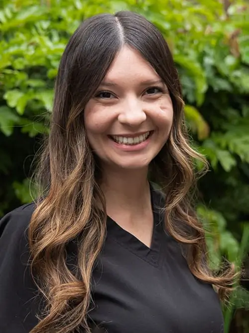 a close up of a woman with long hair smiling at the camera