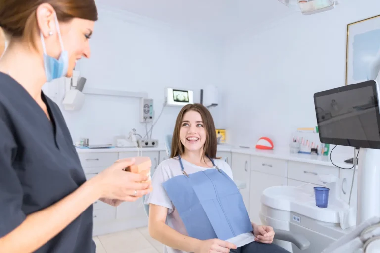 woman in a dental chair with a folder and a computer