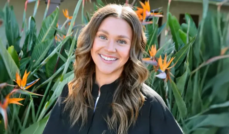 a close up of a woman standing in front of a bunch of flowers