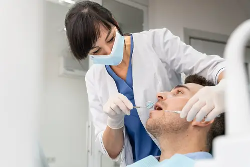 arafed male patient in a dental clinic getting his teeth examined