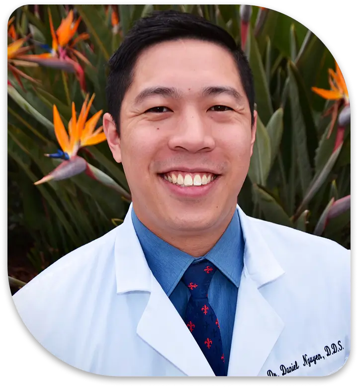 arafed male in a white lab coat and blue tie smiling